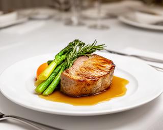 Three-course plated wedding dinner with roasted meat and seasonal vegetables on a white ceramic plate